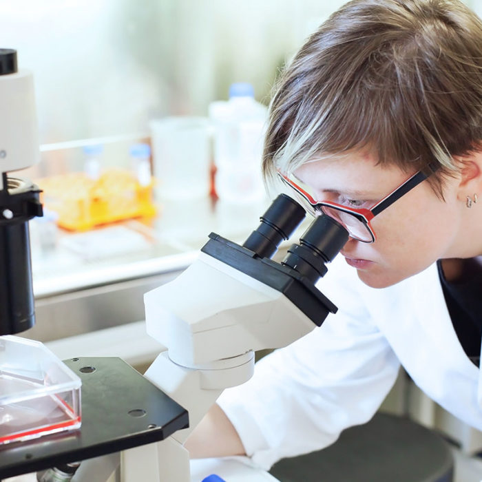 Woman,Scientist,Looking,At,The,Microscope